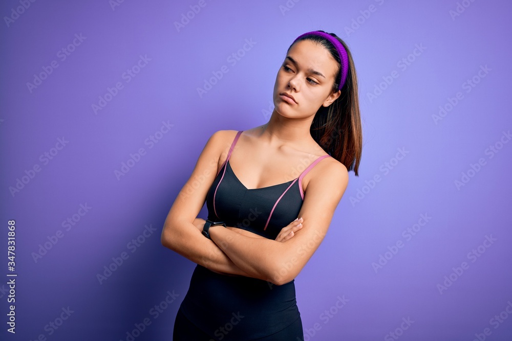 Young beautiful sporty girl doing sport wearing sportswear over isolated purple background looking to the side with arms crossed convinced and confident Young beautiful sporty girl doing sport wearing sportswear over isolated purple background looking to the side with arms crossed convinced and confident