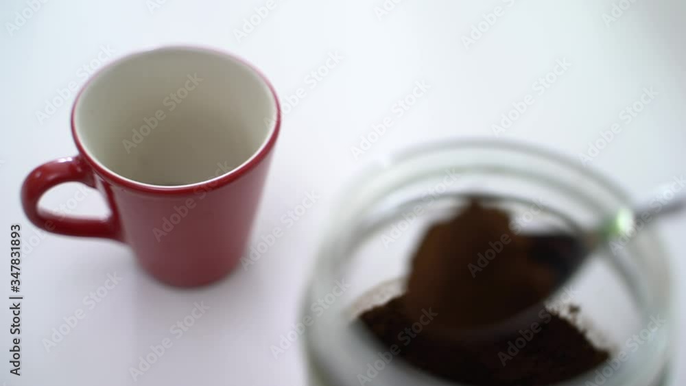 Top view and close up of person male hand put the coffee powder with spoon into the red coffee cup. 4k resolution. Top view and close up of person male hand put the coffee powder with spoon into the red coffee cup. 4k resolution.