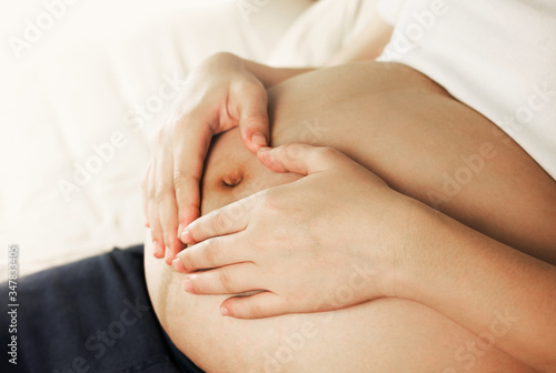 pregnant woman making her hand in love on belly