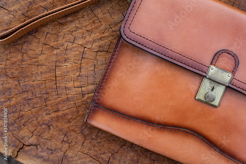 Brown leather wallet on wood texture.