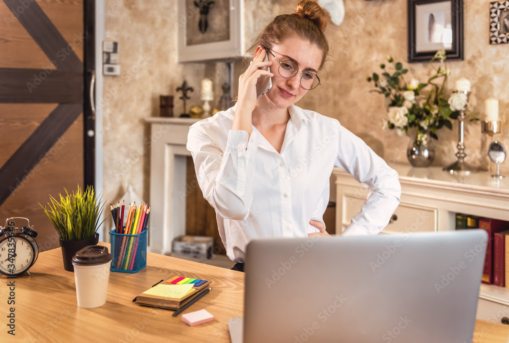 Busy working. Confident young woman in formal wear with documents and talking on the telephone while sitting at her home. Busy working. Confident young woman in formal wear with documents and talking on the telephone while sitting at her home.