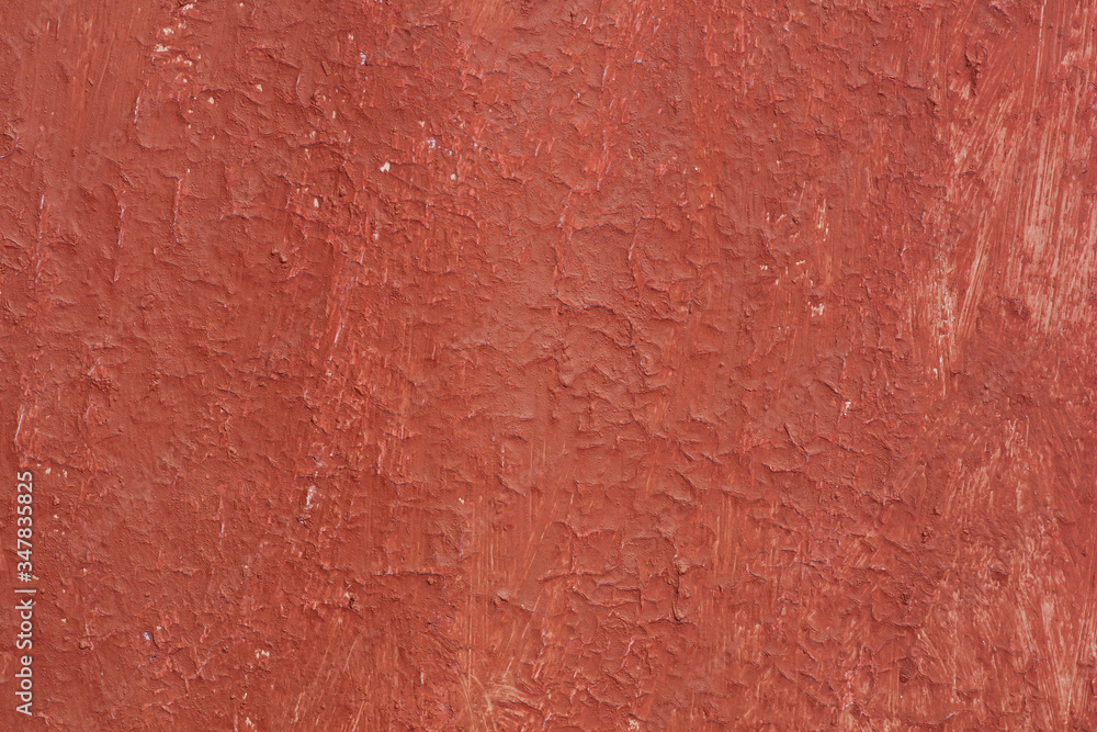 Beautiful vintage red background with old red paint with rough surface, streaks and uneven texture of red paint on old rough surface