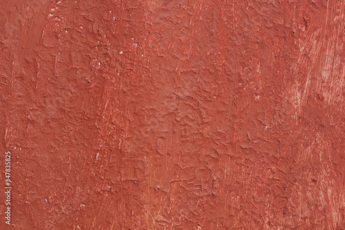 Beautiful vintage red background with old red paint with rough surface, streaks and uneven texture of red paint on old rough surface