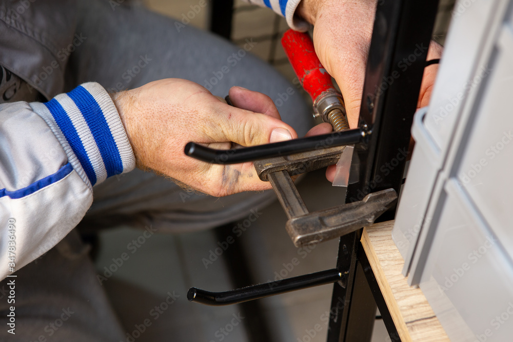 The hand of a master worker installing a shelf in a shop. The hand of a master worker installing a shelf in a shop.