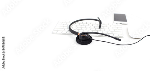 VOIP headset on laptop computer keyboard. Communication support for callcenter and customer service Helpdesk. Isolated on white background. top view flat lay background. Space for text design..