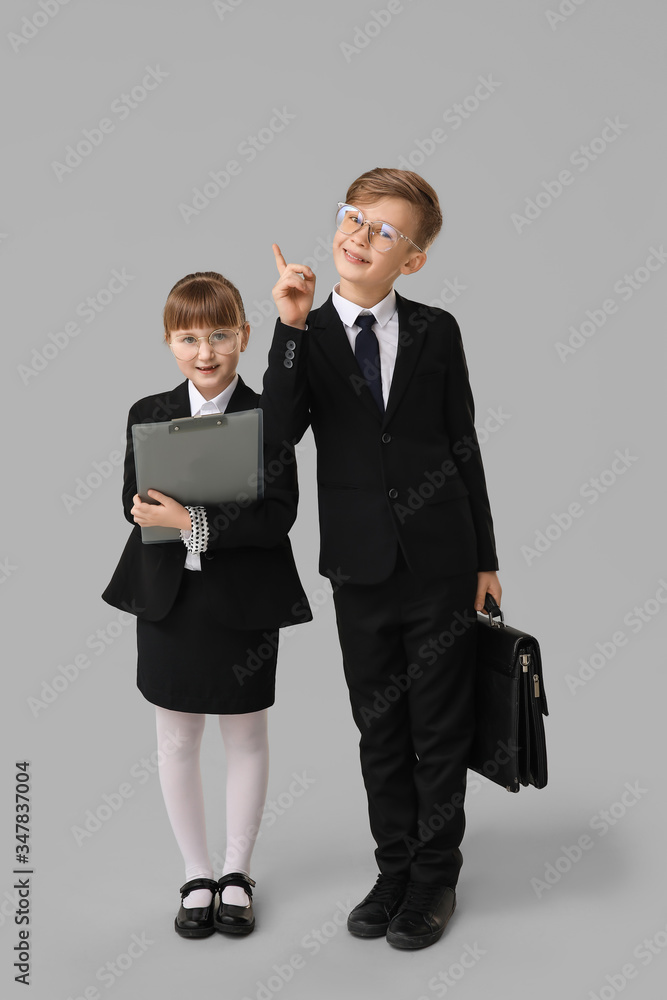 Portrait of little secretaries on grey background Portrait of little secretaries on grey background