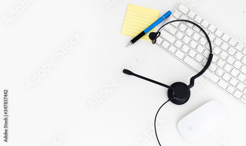 VOIP headset, pen and paper note on laptop computer keyboard. Communication support for callcenter and customer service Helpdesk. 