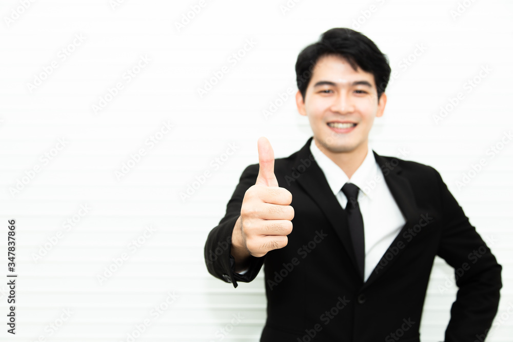 Young success businessman with black suite thumbs up posing and smiling at camera. Business and office concept Young success businessman with black suite thumbs up posing and smiling at camera. Business and office concept