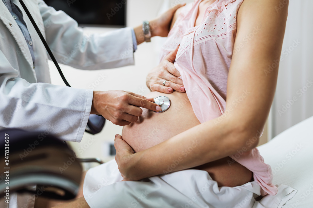 Gynecology examination and consultation. Pregnant woman with her doctor at clinic.