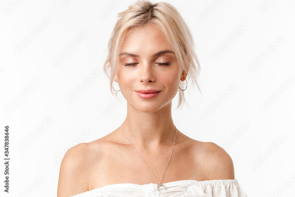 Image of calm blonde woman in earrings posing with eyes closed Image of calm blonde woman in earrings posing with eyes closed