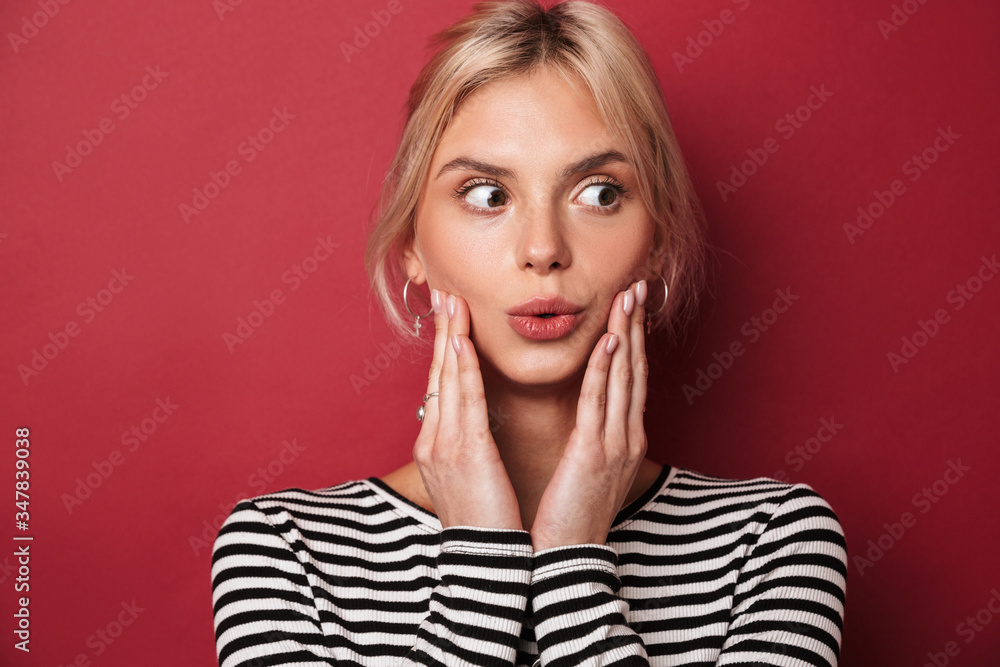 Image of nice shocked woman in striped sweatshirt expressing surprise Image of nice shocked woman in striped sweatshirt expressing surprise