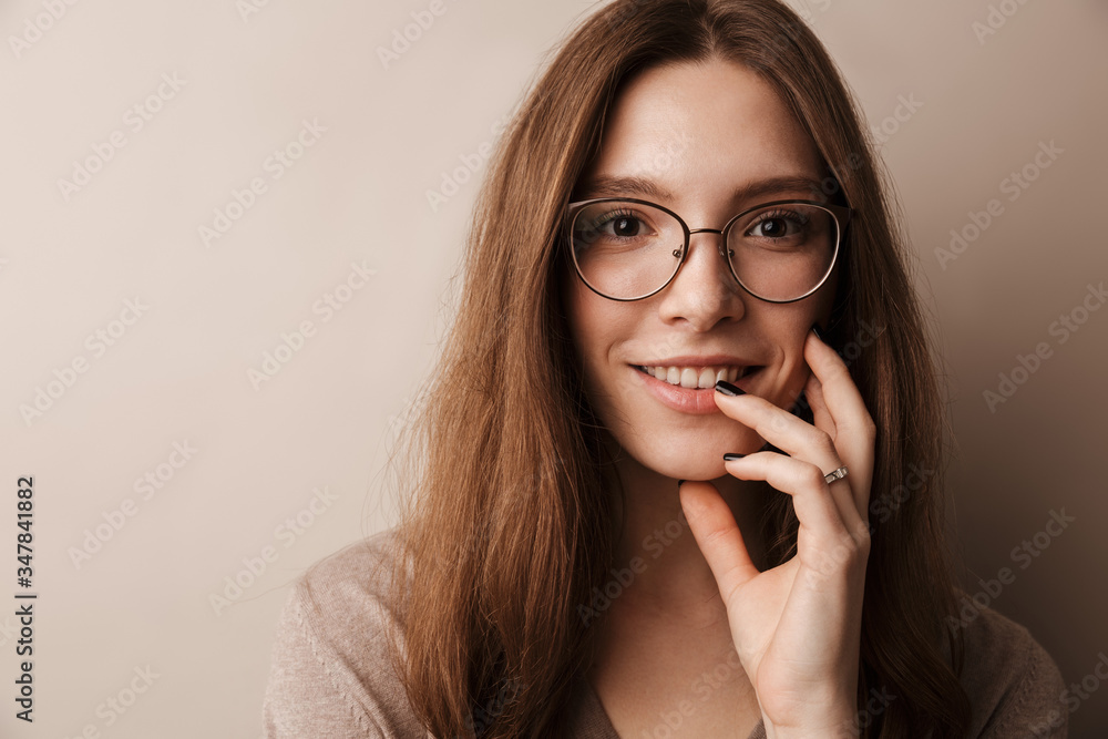 Photo of young happy woman in eyeglasses smiling and looking at camera