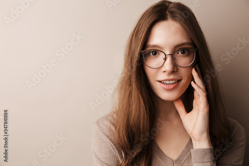 Photo of young happy woman in eyeglasses smiling and looking at camera