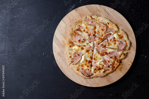 selbstgemachte Pizza mit Mascarpone , Mozzarella und Truthanschinken, geschnitten, Studio