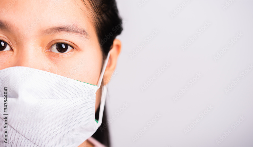 Asian beautiful woman wearing protection face mask against coronavirus her looking to camera, studio shot isolated on white background with copy space, COVID-19 or corona virus concept Asian beautiful woman wearing protection face mask against coronavirus her looking to camera, studio shot isolated on white background with copy space, COVID-19 or corona virus concept