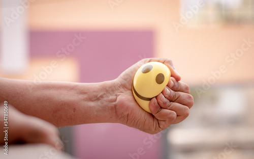 Hands squeezing or pressing stress ball at home to release stress - concept of stress buster photo