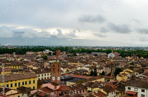 From the Guinigi's tower a landscape aerial view of the typical italian red roofs of the medieval town of Lucca in Tuscany, Italy during a rainy winter day 