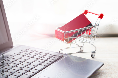 Laptop and shopping cart with a credit card.