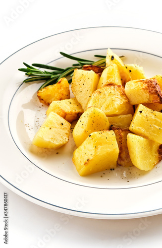 Fried baked potatoes with rosemary on a white plate