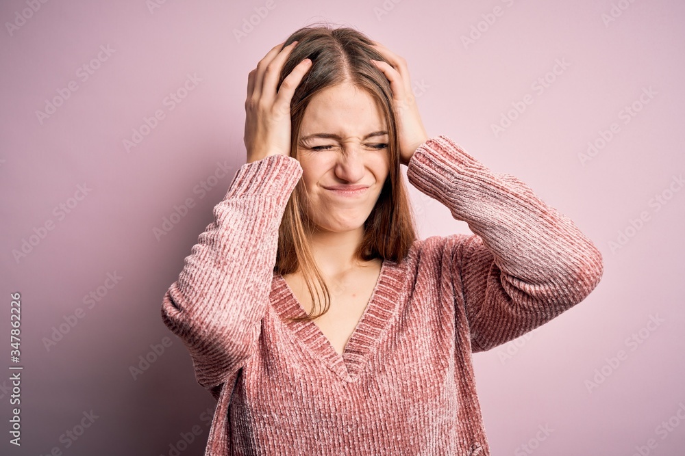 Young beautiful redhead woman wearing casual sweater over isolated pink background suffering from headache desperate and stressed because pain and migraine. Hands on head. Young beautiful redhead woman wearing casual sweater over isolated pink background suffering from headache desperate and stressed because pain and migraine. Hands on head.
