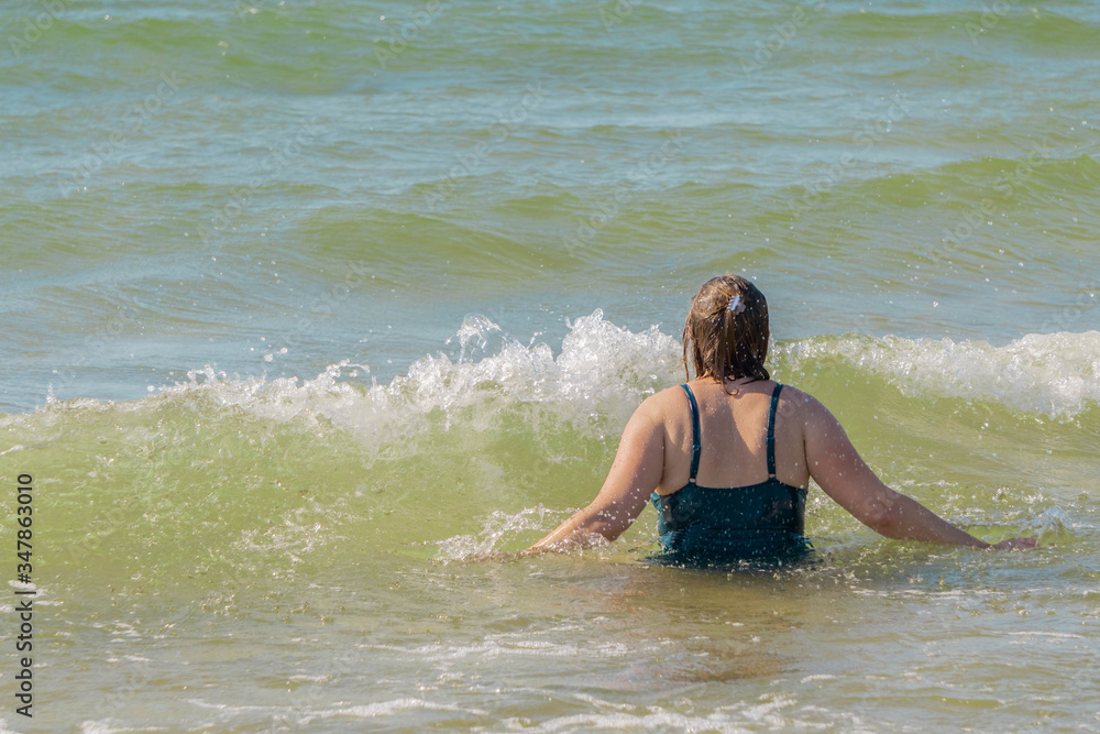 Woman going into waving sea for swimming