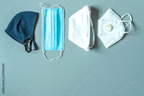 Different face masks and respirator on blue background. Protection against virus photo