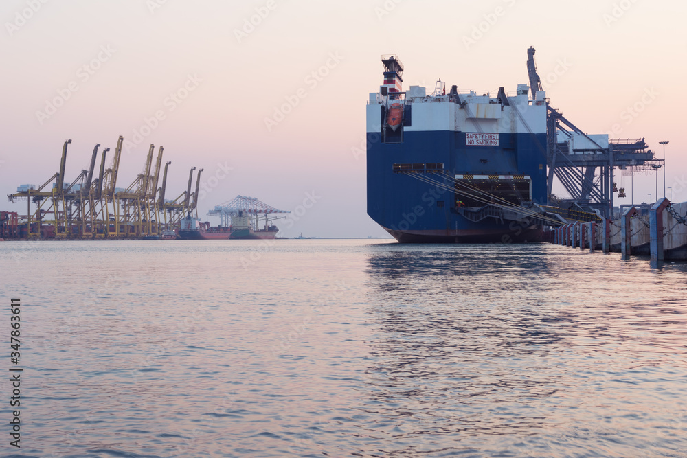 Obraz premium Huge container cargo ship on harbor while load car into it