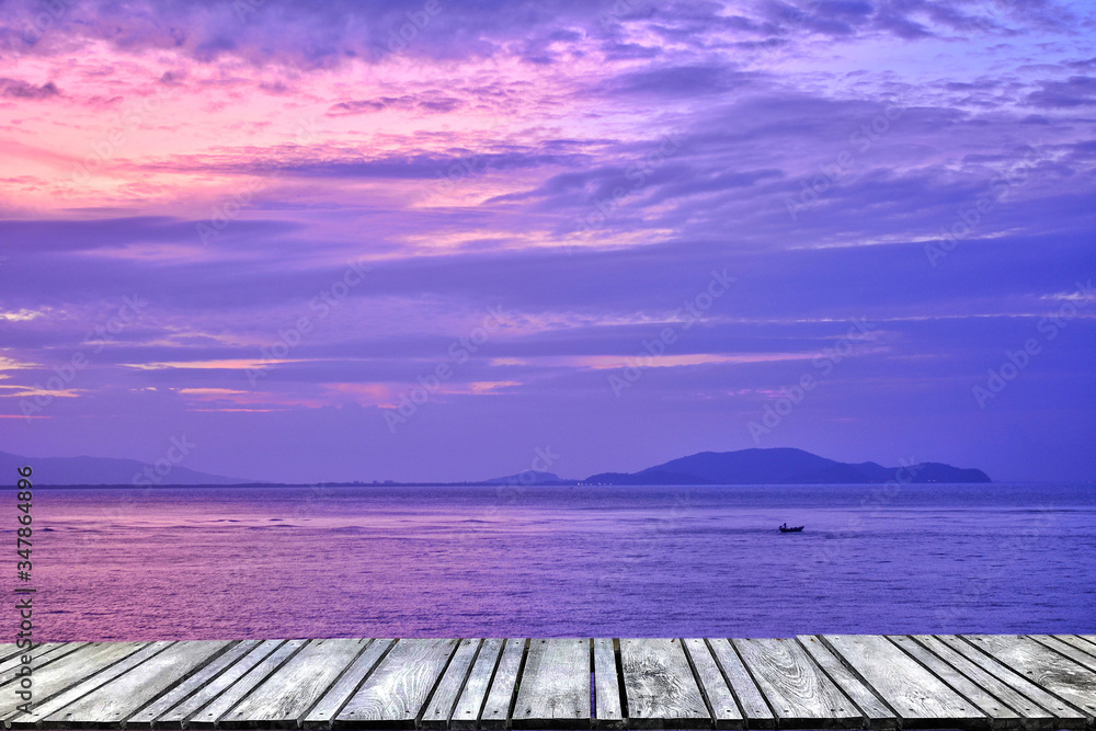 Sunset at sea and old wooden bridgeมPerspective view of wooden pier on the sea at sunset with perfectly specular reflection,wooden retro deck and sunrise or sunset sky/ Summer holidays background.
