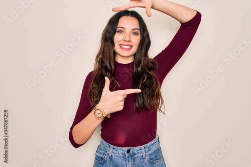 Young beautiful woman wearing casual t-shirt standing over isolated white background smiling making frame with hands and fingers with happy face. Creativity and photography concept.