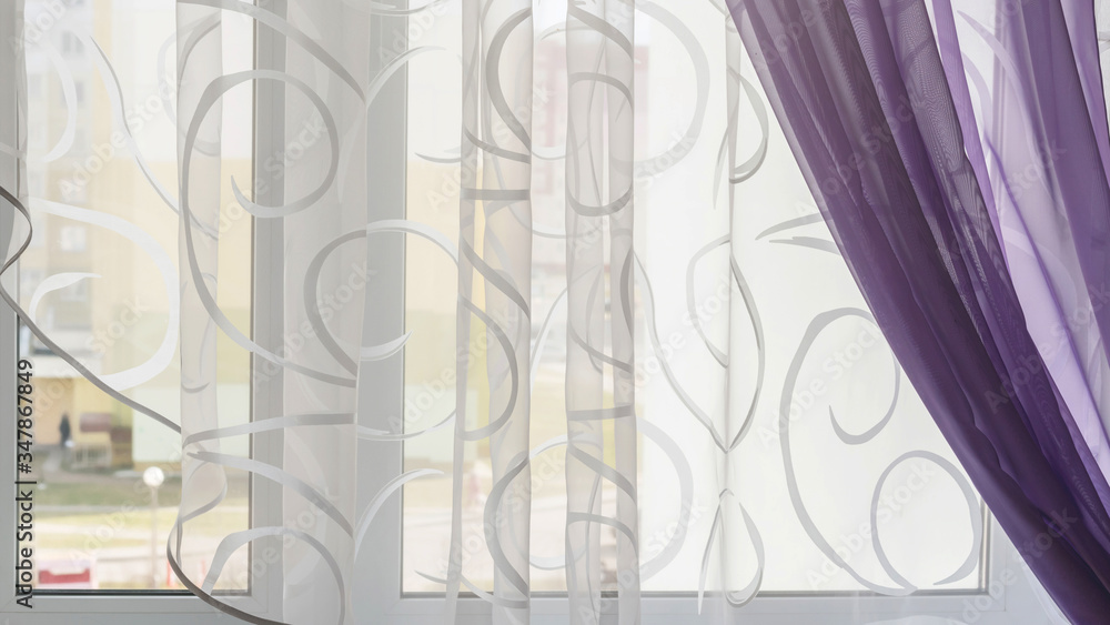 Obraz premium white and purple curtain with rounded edge and swirling lines hangs on window