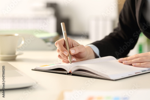 Business woman hands taking notes writing on agenda
