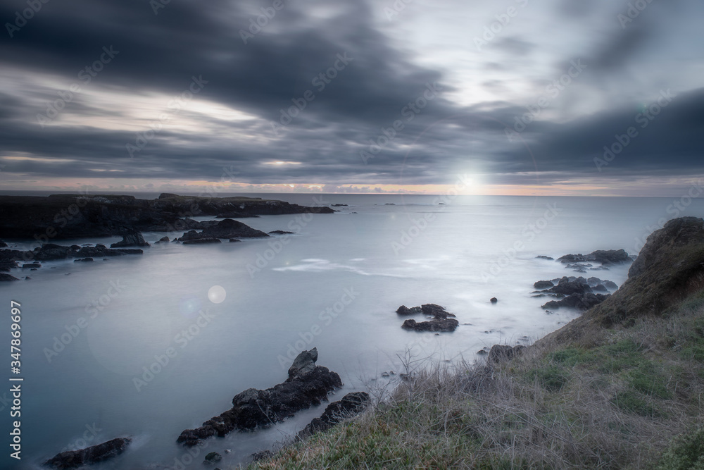 Sunset in Mendocino Headlands State Park, California, USA, with lens flare and long exposure, giving a sense of peace and tranquility