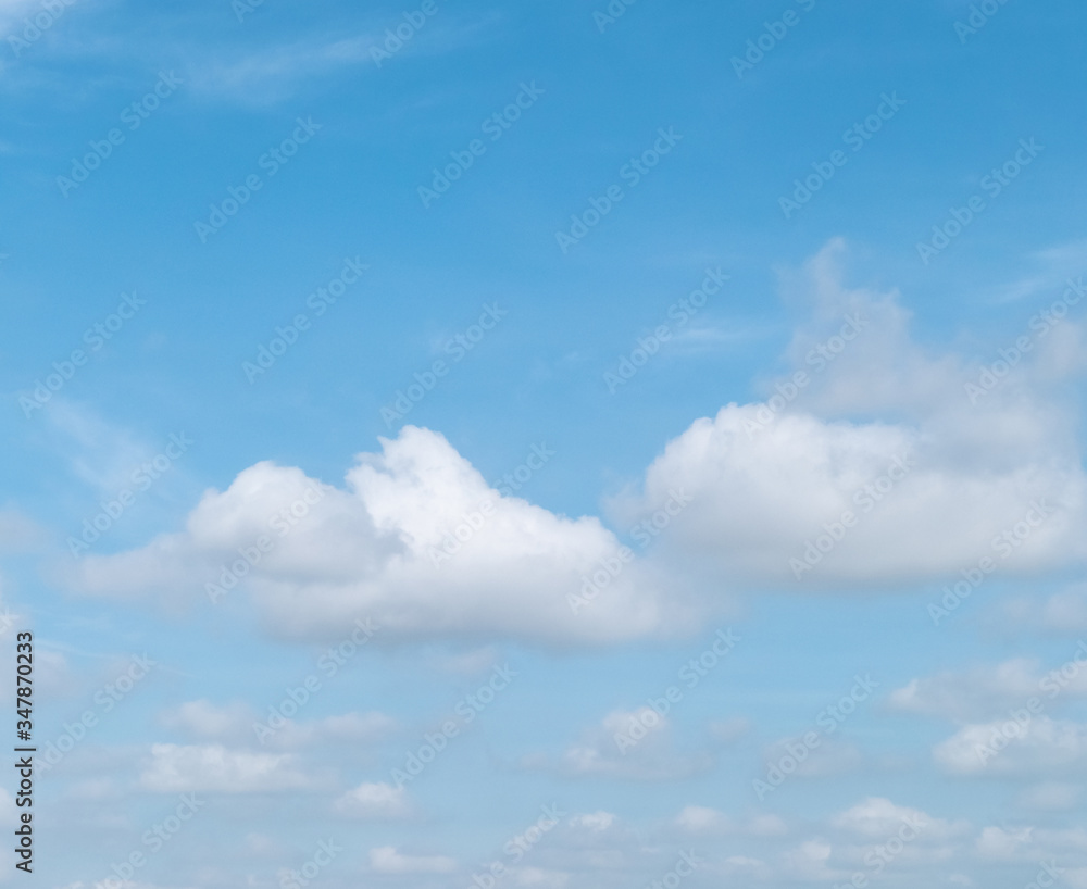 Blue sky with white soft clouds. Simple outdoor sky background.
