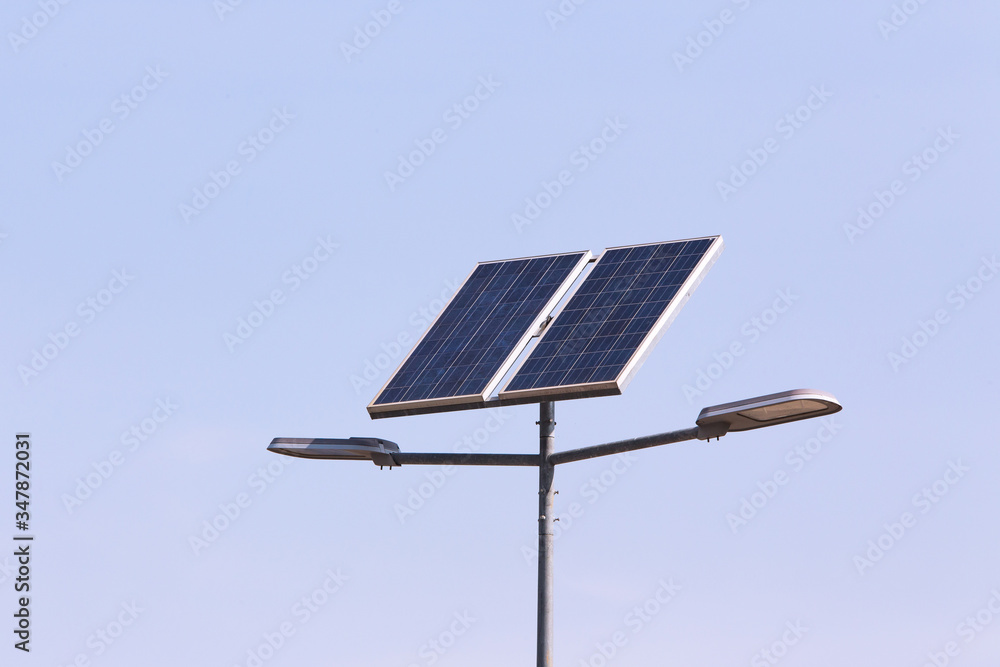 Obraz premium street lamp post with solar panel energy (against blue sky background)