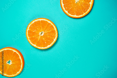 Fresh orange on the light turquoise background. View from above. Place for text.