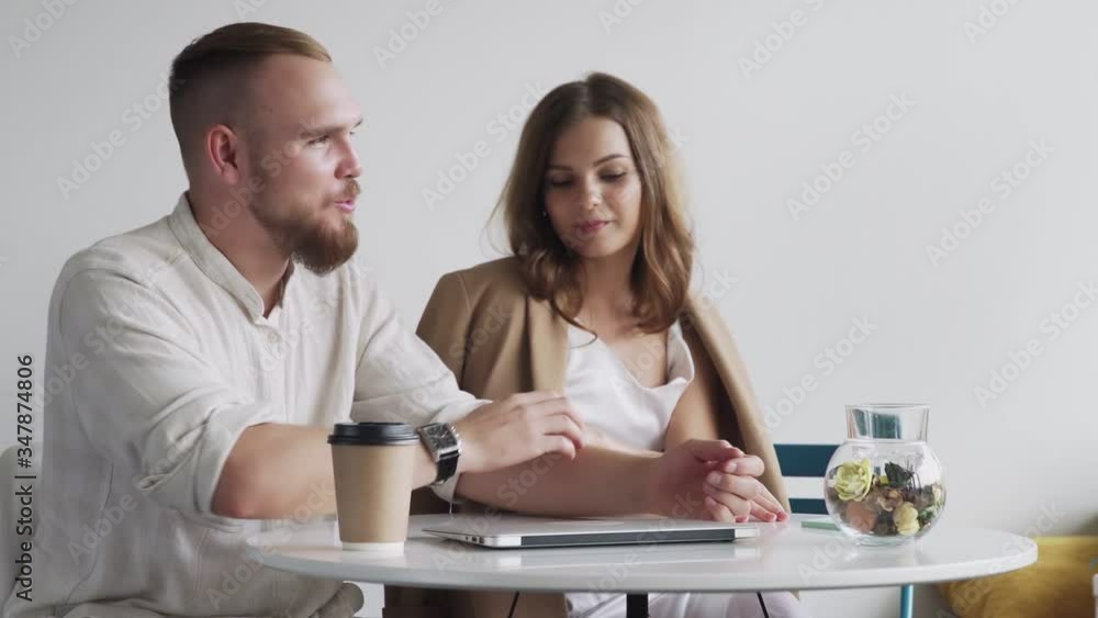 Attractive couple using laptop and talking in home Attractive couple using laptop and talking in home