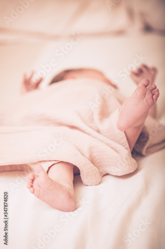 Close up picture of newborn baby feet. Sleeping newborn baby on a light blanket.