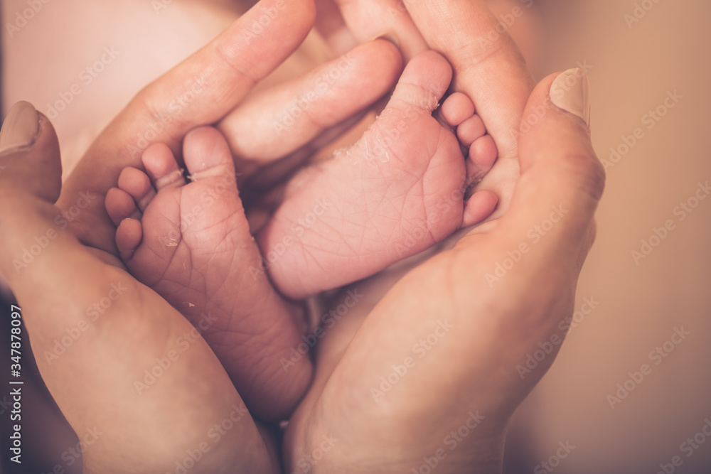 Baby feet in mother hands. Tiny Newborn Baby's feet on female Heart Shaped hands closeup. Mom and her Child. Happy Family concept. Beautiful conceptual image of Maternity. Baby feet in mother hands. Tiny Newborn Baby's feet on female Heart Shaped hands closeup. Mom and her Child. Happy Family concept. Beautiful conceptual image of Maternity.