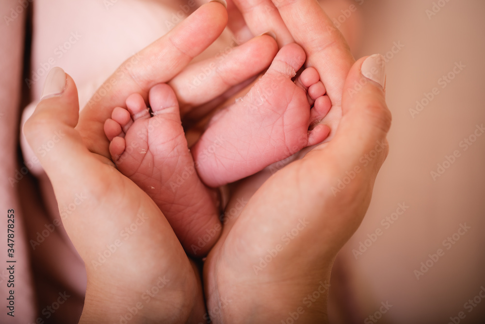 Baby feet in mother hands. Tiny Newborn Baby's feet on female Heart Shaped hands closeup. Mom and her Child. Happy Family concept. Beautiful conceptual image of Maternity. Baby feet in mother hands. Tiny Newborn Baby's feet on female Heart Shaped hands closeup. Mom and her Child. Happy Family concept. Beautiful conceptual image of Maternity.