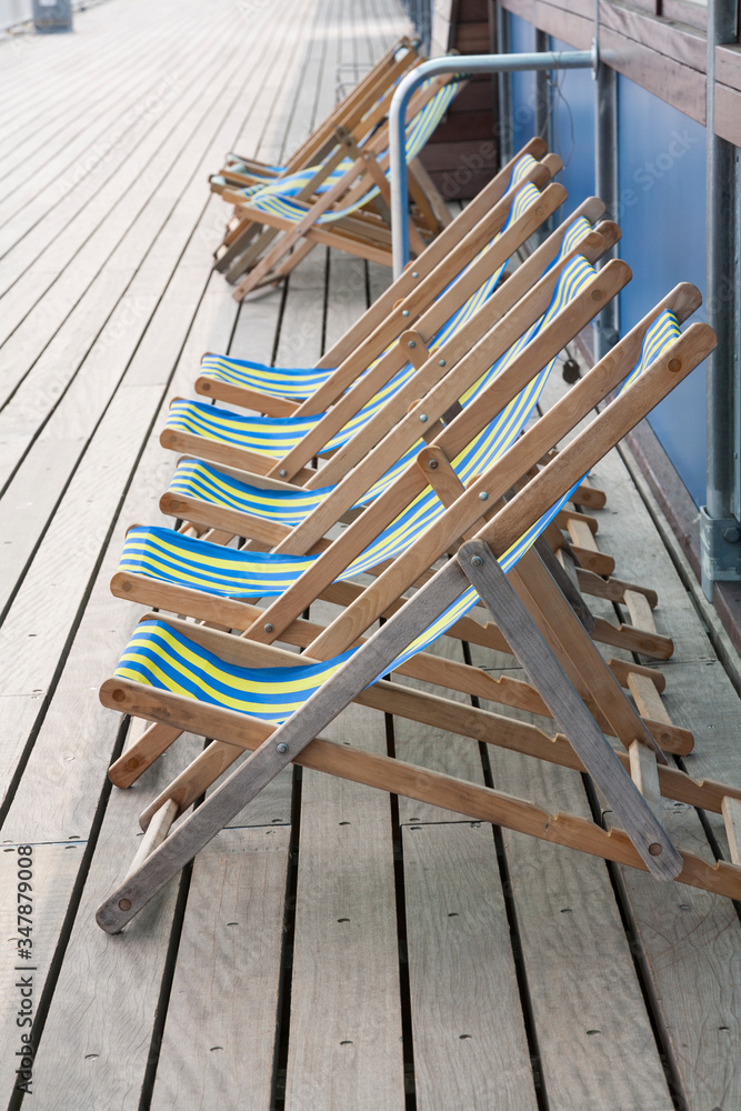 stripey wooden deck chairs on the pier stripey wooden deck chairs on the pier