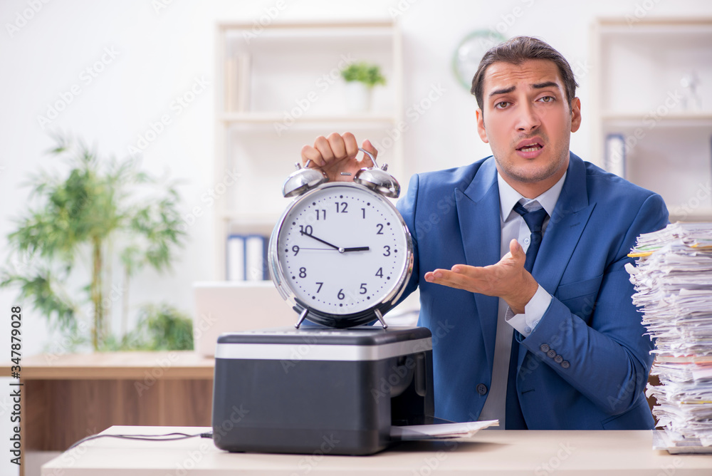 Young male employee making copies at copying machine Young male employee making copies at copying machine