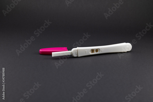 Positive pregnancy test in white and rose tones. Vertical stripes for positive in black background with copy space. 