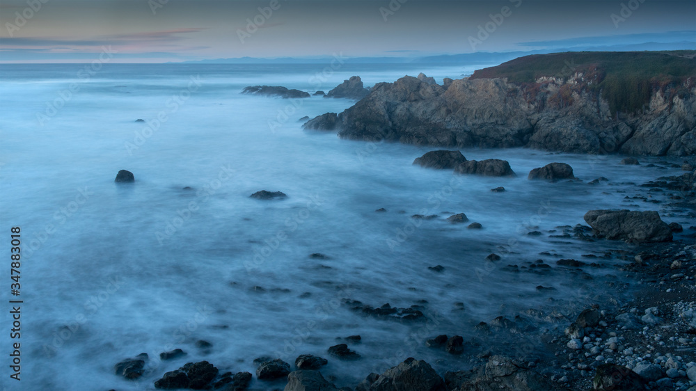 Long exposure of glass beach area in Mendocino, Fort Bragg, California, USA, featuring blue hues and a peaceful scene