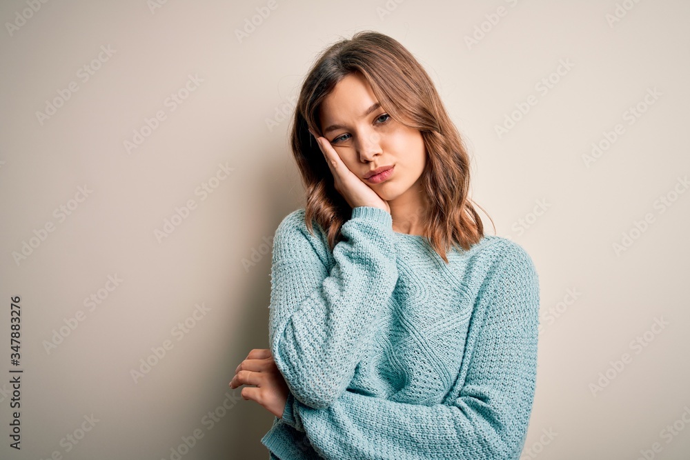 Young blonde girl wearing casual blue winter sweater over isolated background thinking looking tired and bored with depression problems with crossed arms. Young blonde girl wearing casual blue winter sweater over isolated background thinking looking tired and bored with depression problems with crossed arms.