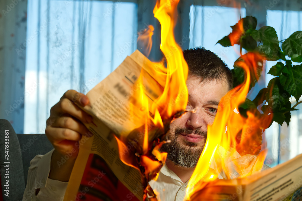 businessman reading hot news or reading stock market news share prices. Burning magazine in man's hands - hot and breaking news concept
