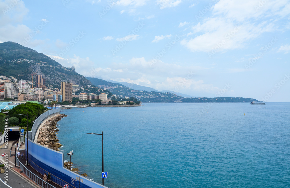 A famous view of Mediterranean coastline with ships, and luxury residential apartment buildings in Monte Carlo Principality of Monaco