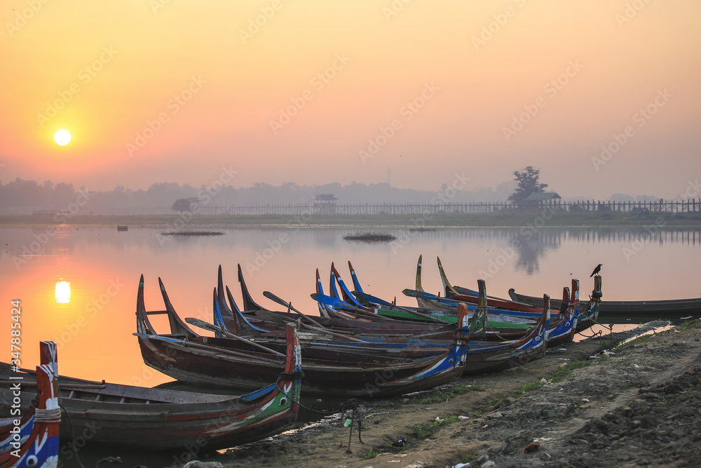 Colorful boats on the shore with sunrise near U Bein Bridge, Taungthaman Lake near Amarapura, Myanmar