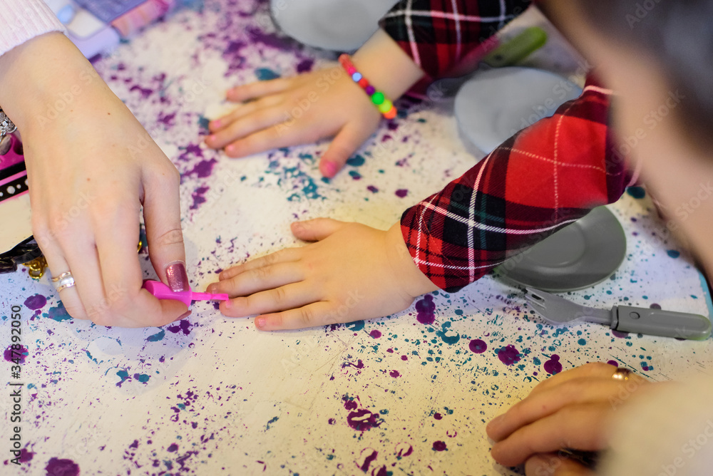 Mother paints her child's nails with nail polish Mother paints her child's nails with nail polish