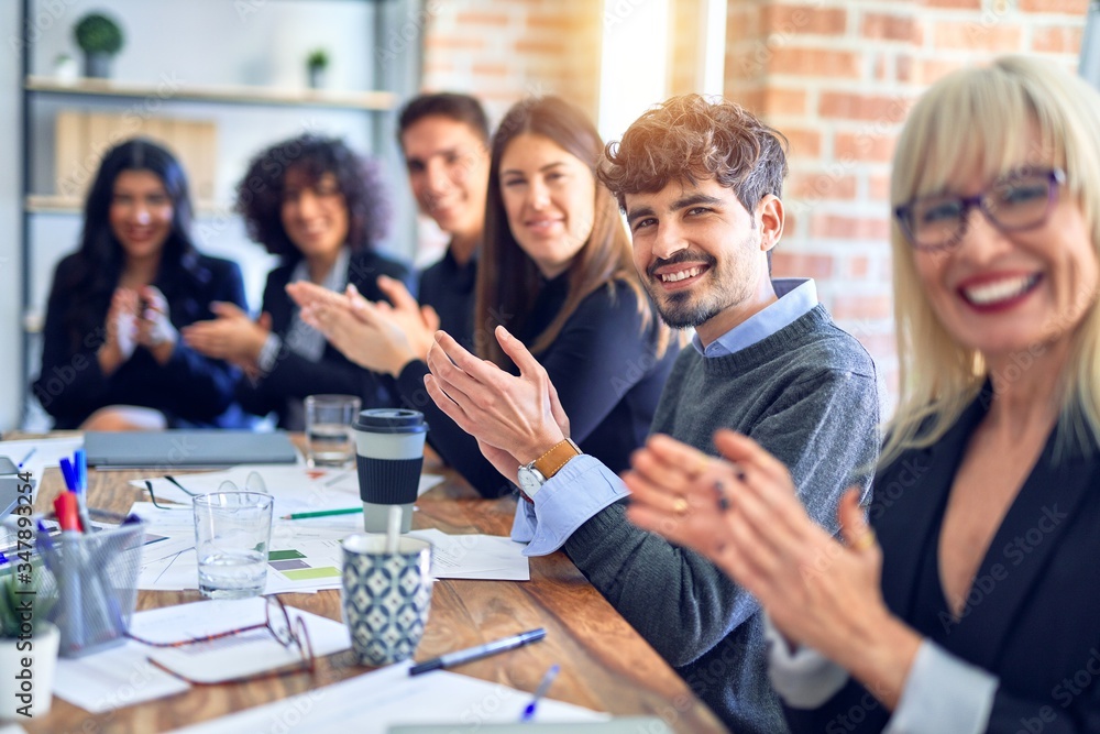 Group of business workers smiling happy and confident. Working together with smile on face looking at the camera applauding at the office Group of business workers smiling happy and confident. Working together with smile on face looking at the camera applauding at the office