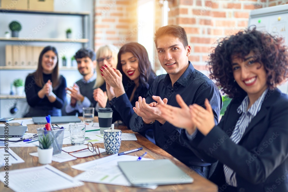 Group of business workers smiling happy and confident. Working together with smile on face looking at the camera applauding at the office Group of business workers smiling happy and confident. Working together with smile on face looking at the camera applauding at the office